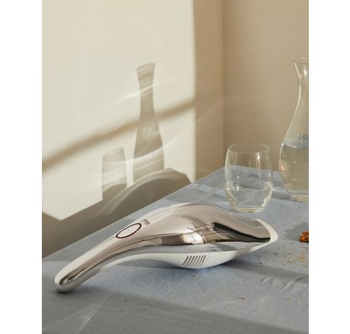 Handheld vacuum cleaner, rechargeable in 18/10 stainless steel mirror polished and thermoplastic resin, white. Charger in thermoplastic resin with integrated crevice tool and wet nozzle. US plug.  Alessi